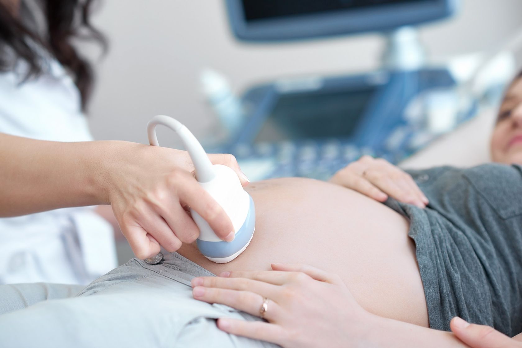 Ultraschalluntersuchung im Rahmen der Schwangerenvorsorge - eine Gynäkologin schallt den schwangeren Bauch.
