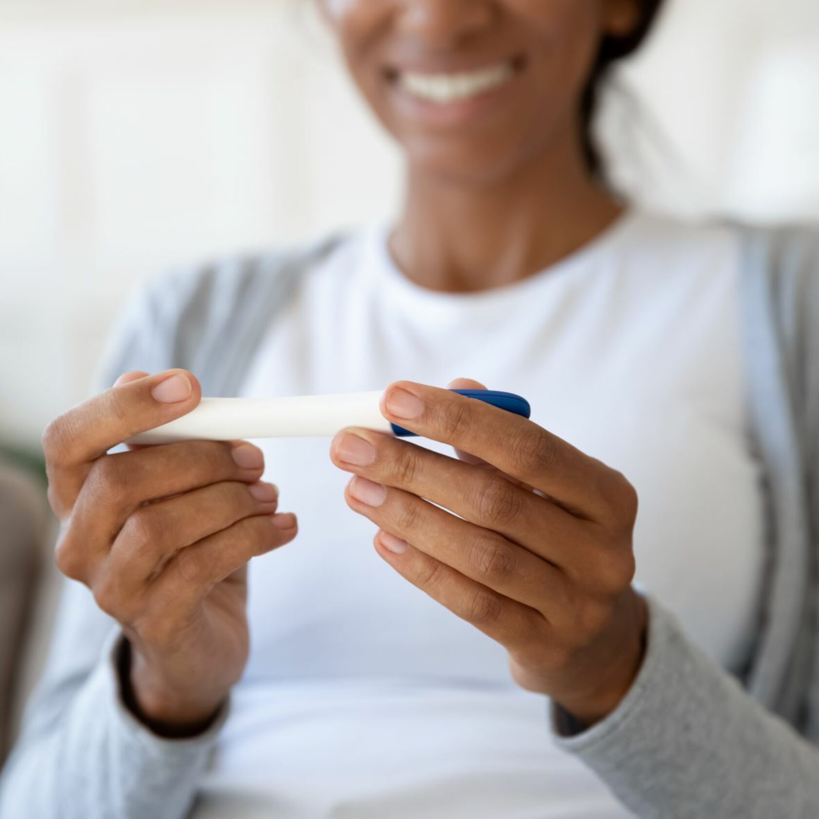 Glückliche Frau mit Schwangerschaftstest