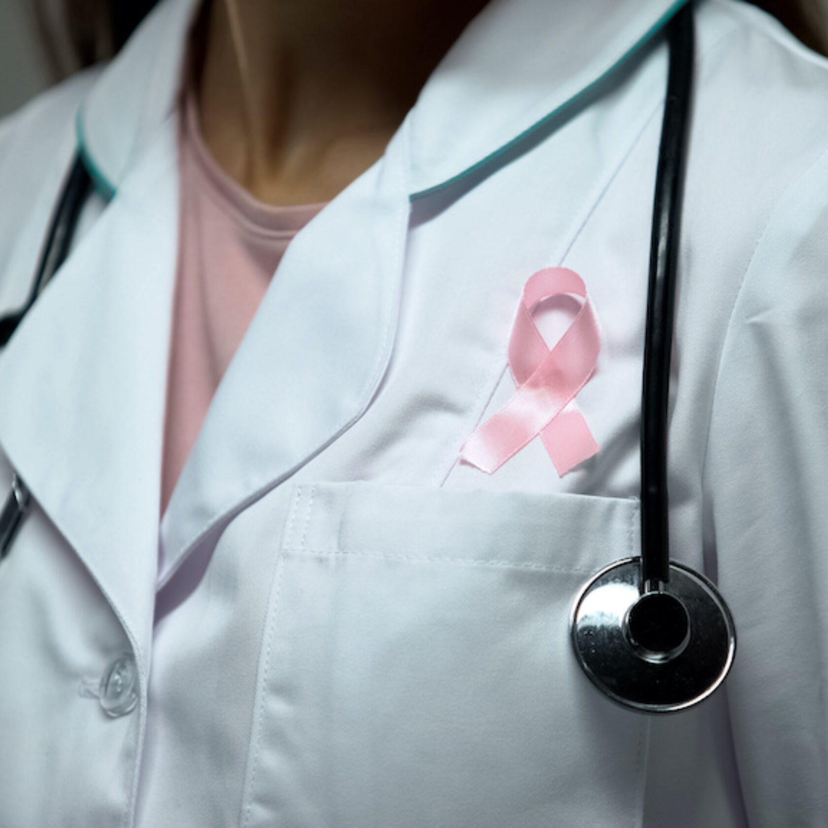 Ärztin mit rosa Schleife am Revers Zeichen für Engagement gegen Brustkrebs