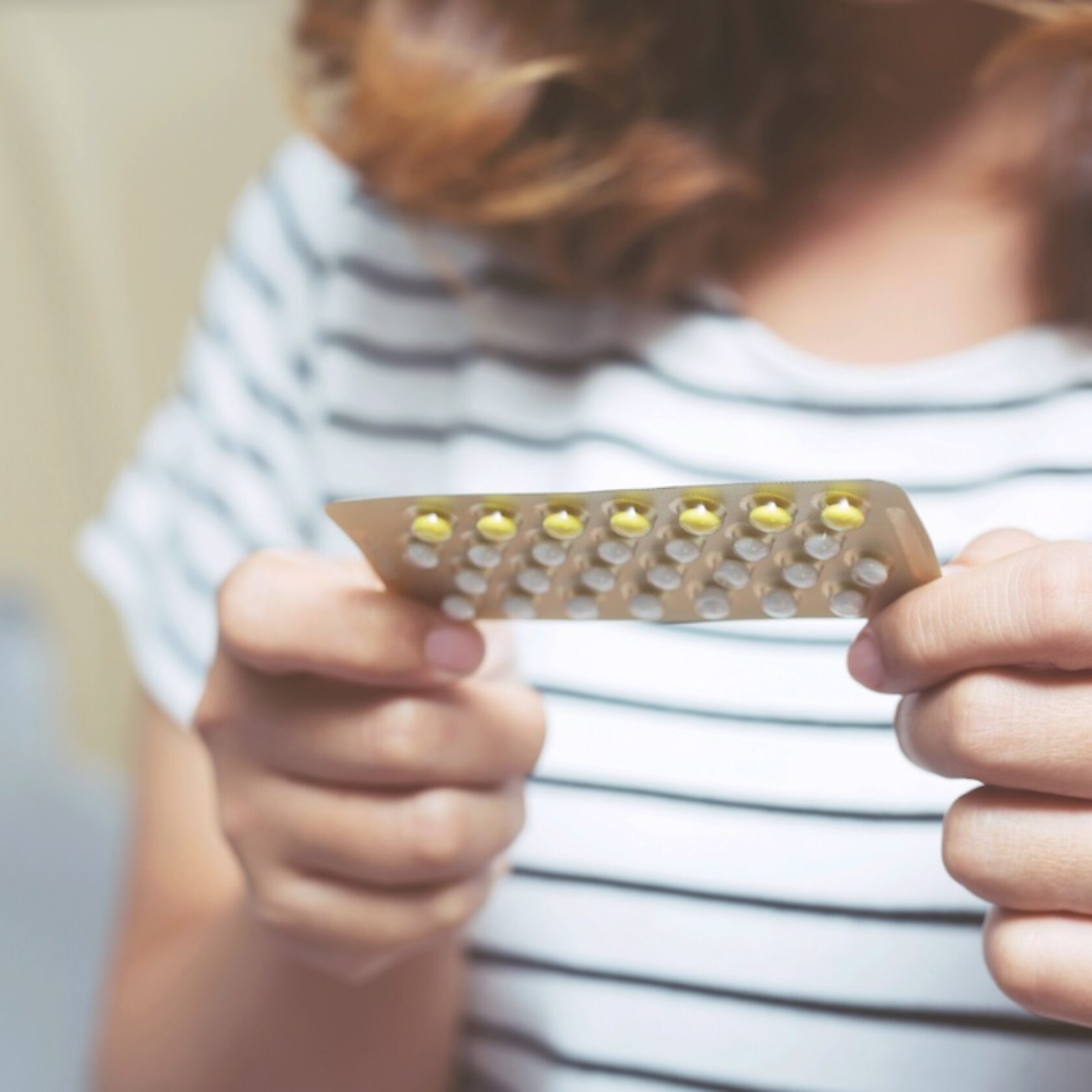 Hände eines Mädchens halten einen Blister der Pille zur hormonalen Empfängnisverhütung 