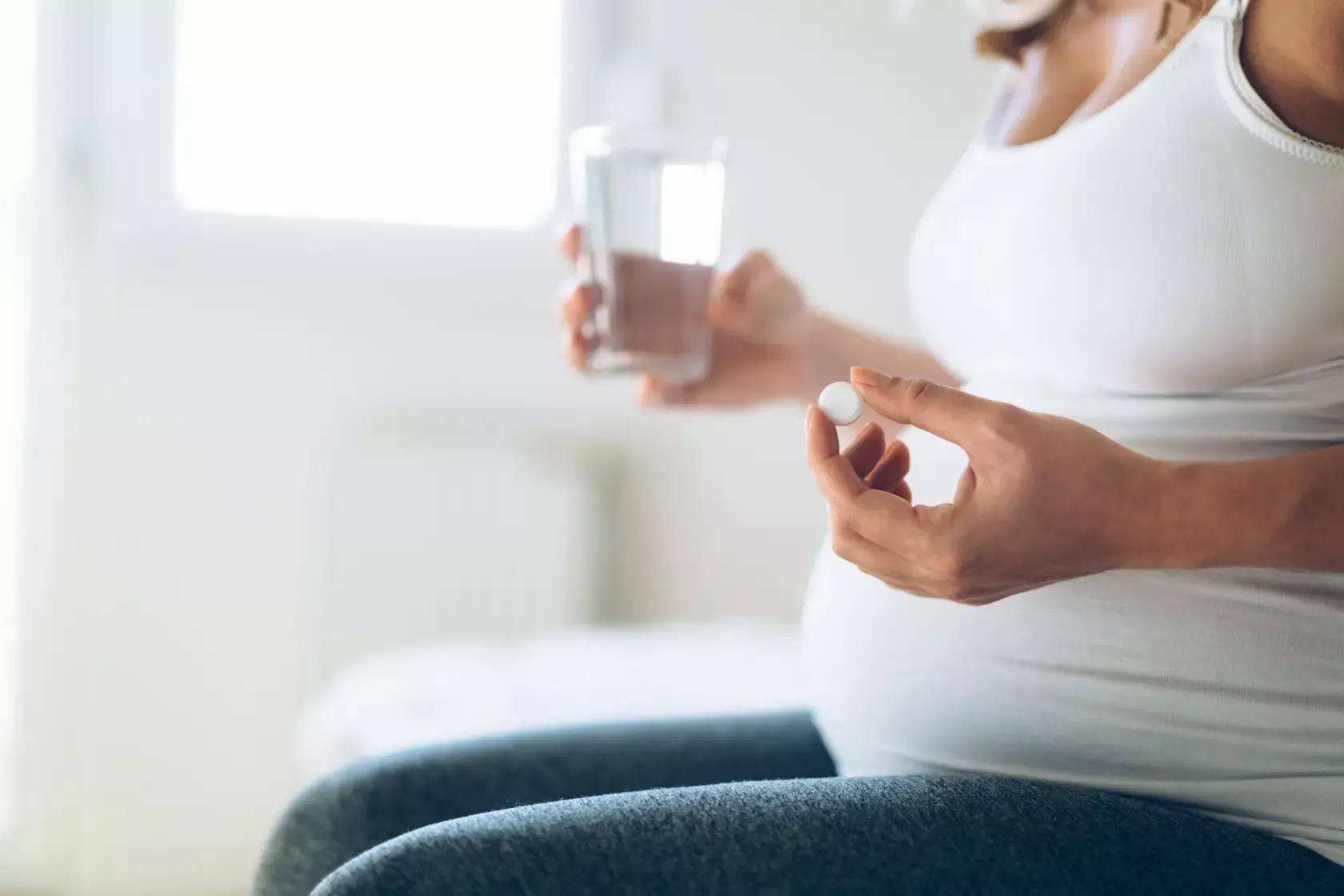 Schwangere nimmt eine Tablette gegen Sodbrennen