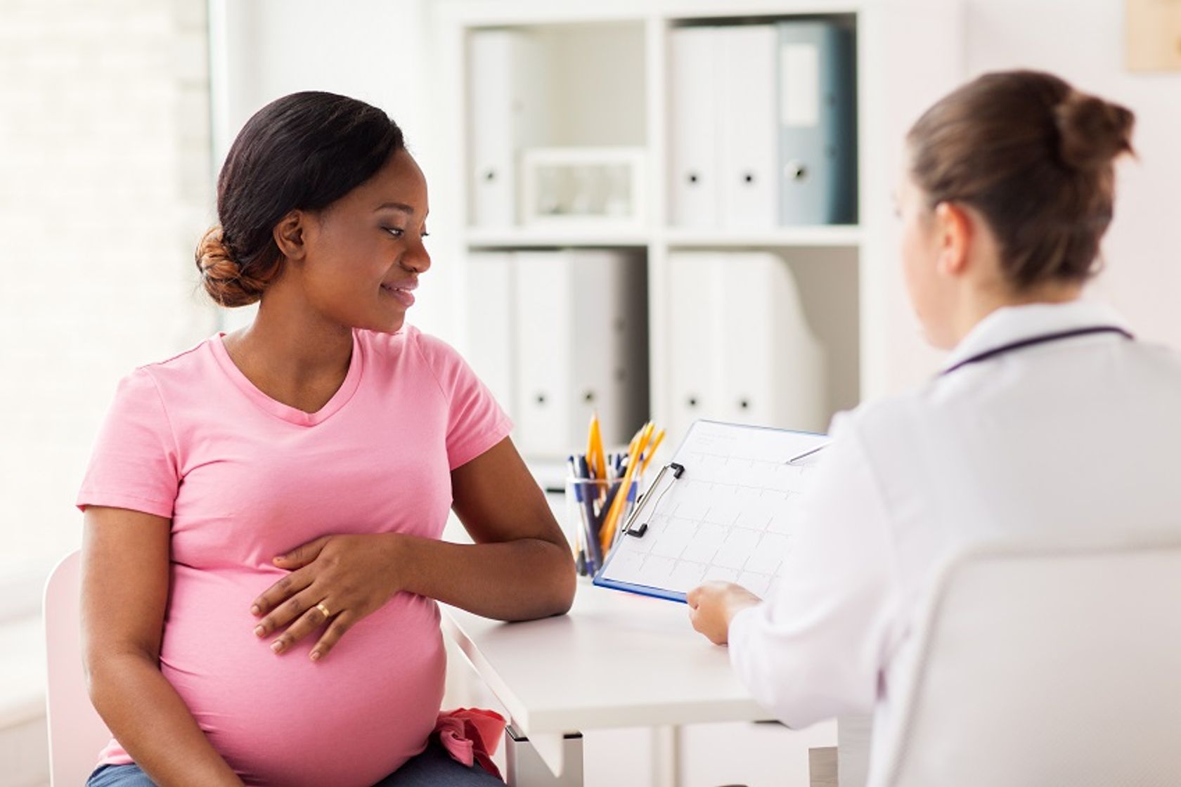 Schwangere Frau im Gespräch mit Arzt